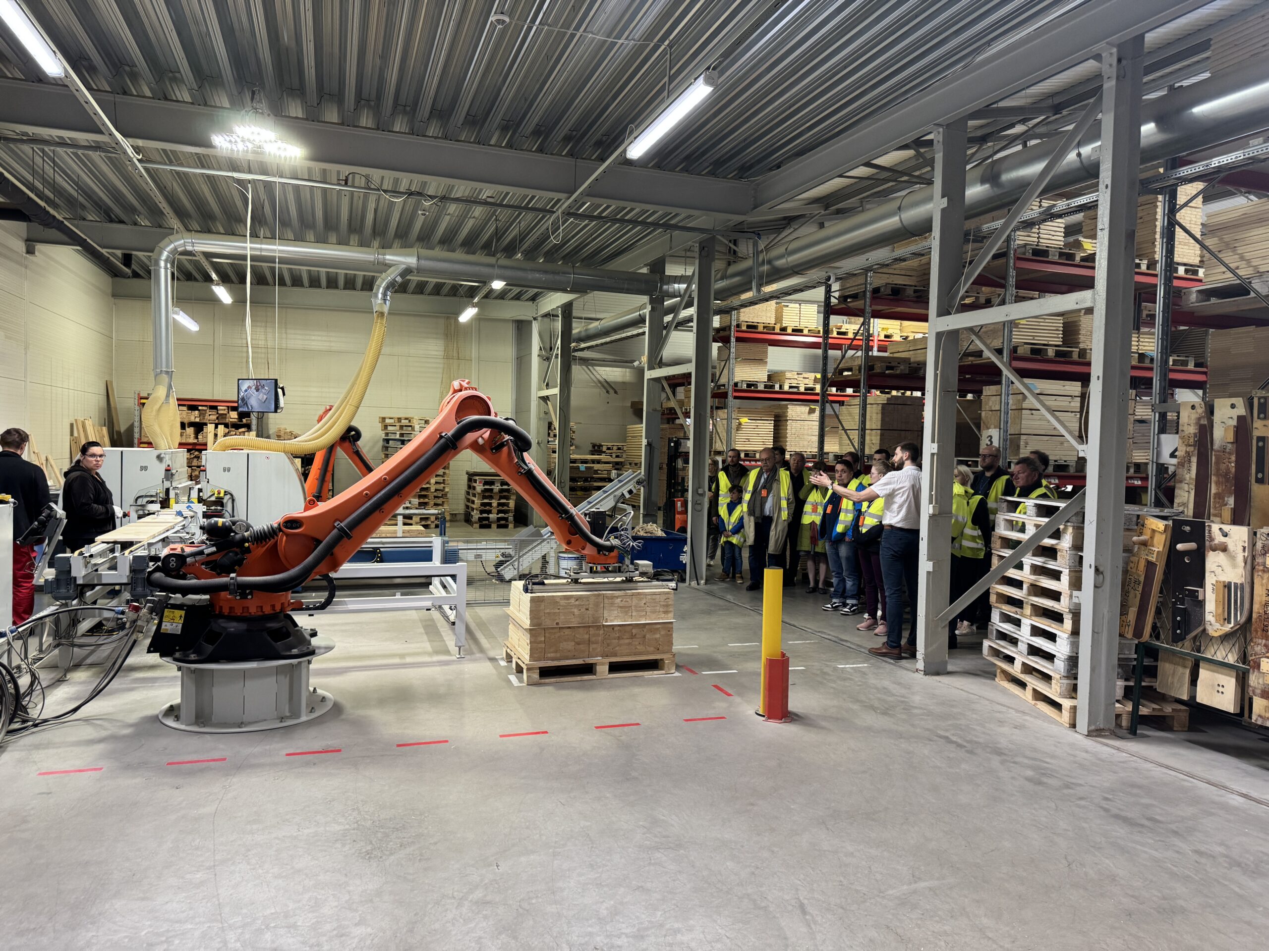 Visitors watching an industrial robot on the Tiksoja production line
